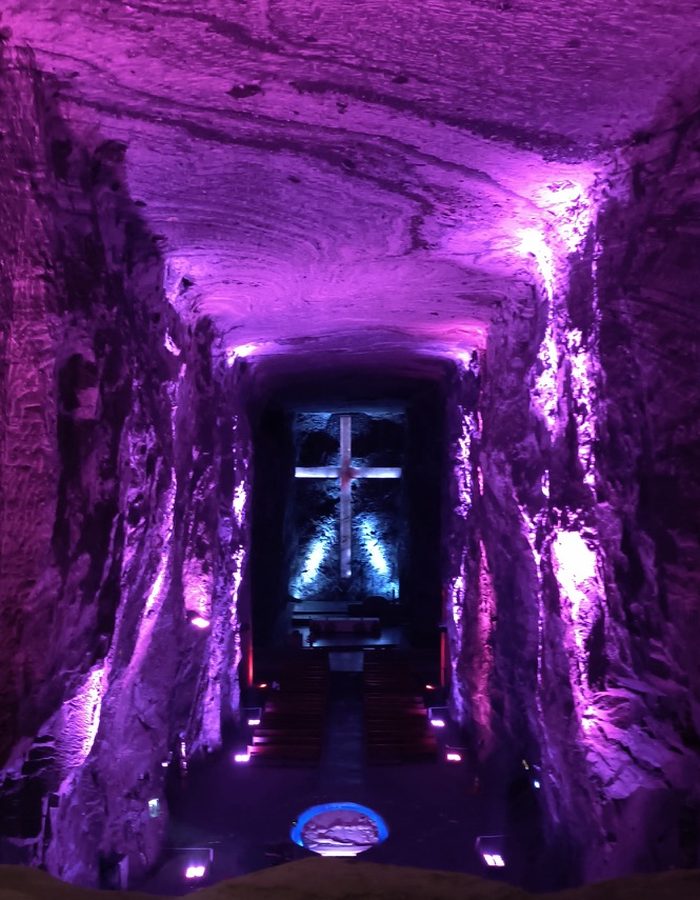 Cruz iluminada en tonos morados dentro de la Catedral de Sal de Zipaquirá