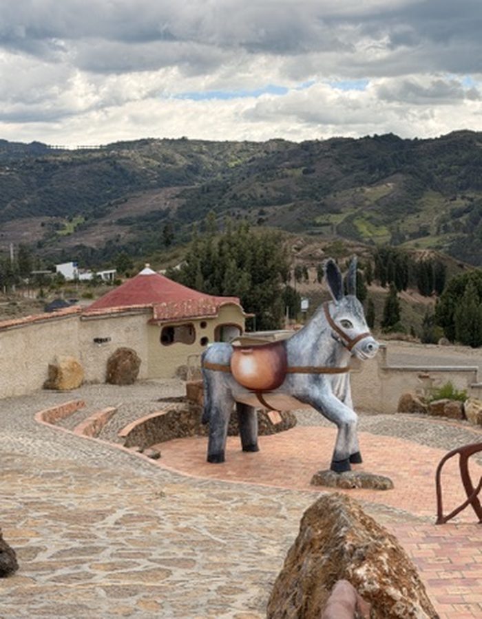 Estatua artesanal de un burro en Ráquira, con vista a las montañas
