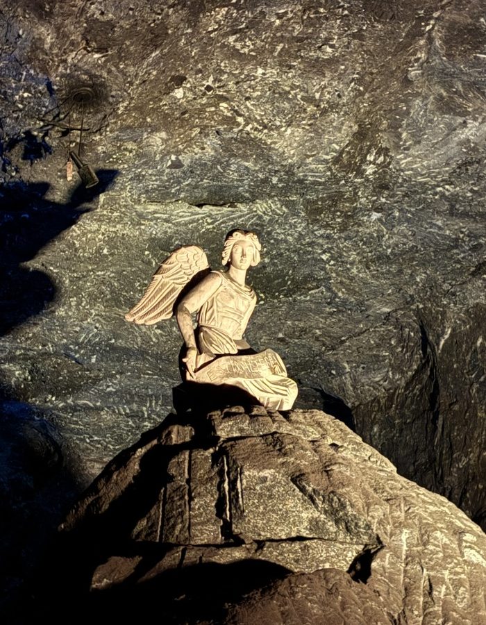 Escultura de ángel tallada en sal con iluminación dorada, en la Catedral de Sal