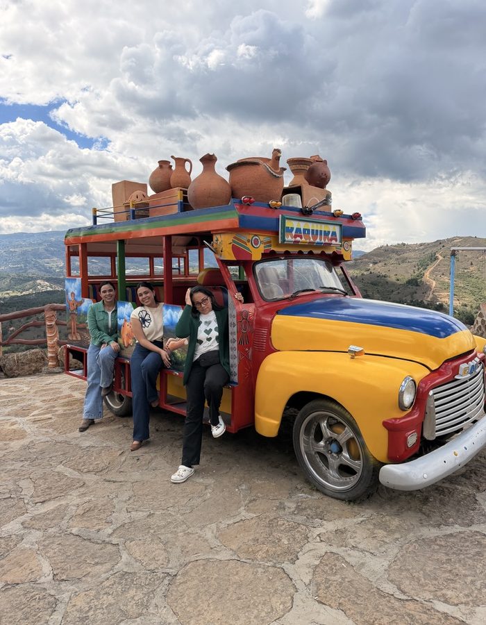 Clientes junto a una chiva colorida en un mirador cerca de Ráquira